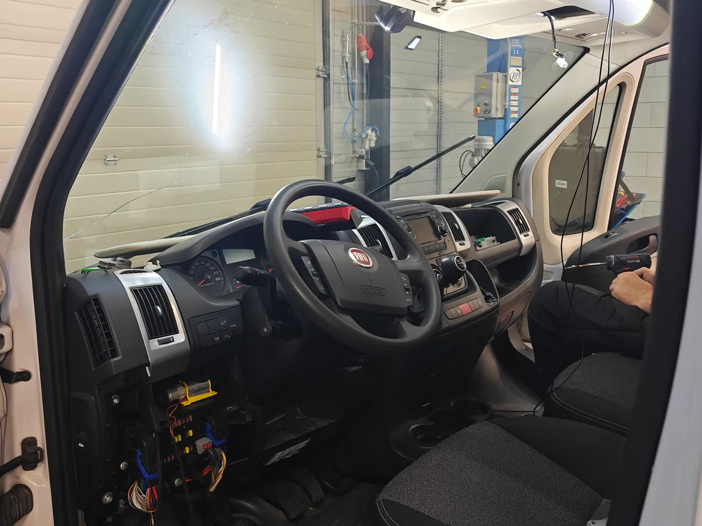 Cabine van een Fiat Ducato met opengelegde zekeringkast en bekabeling tijdens de tachograaf-inbouw, dezelfde bus als de Citroën Jumper