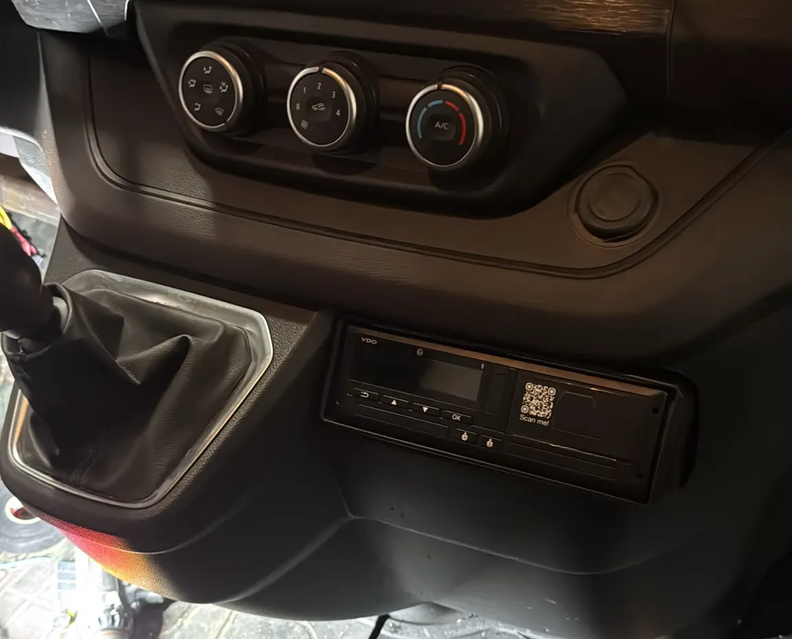 VDO-tachograaf vlak ingebouwd in de middenconsole van een Nissan Primastar, naast de versnellingspook